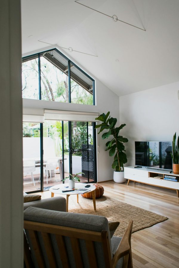 Interior of contemporary cozy living room with modern TV and soft armchairs in daylight